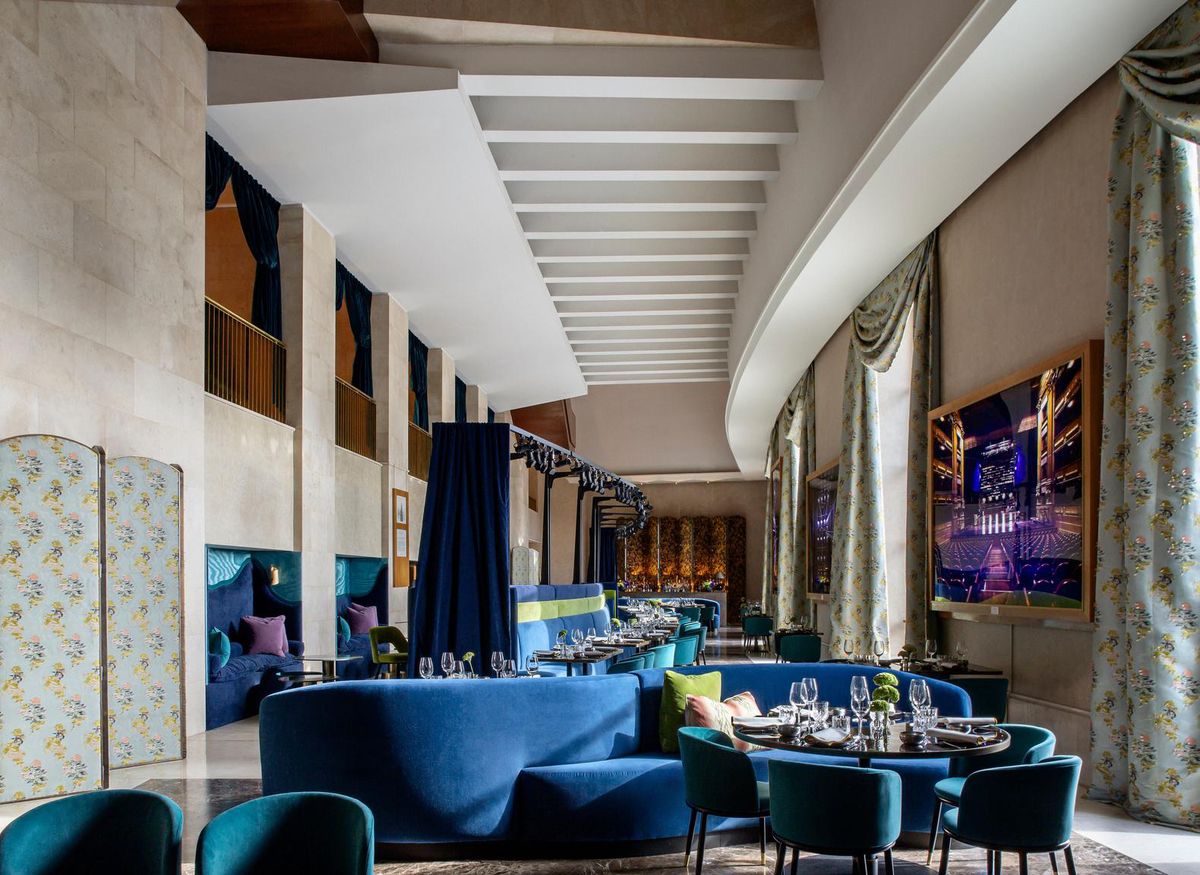 The dining room at Papagena on the sixth floor of the Teatro Real in Madrid, with blue sofas, high ceilings and large windows